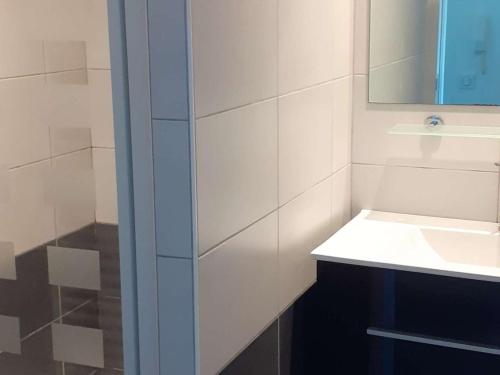 une salle de bain blanche avec un lavabo et un miroir dans l'établissement Appartement neuf lumineux avec balcon, Wi-Fi, au pied de la plage du Chay, Royan - FR-1-494-126, à Royan