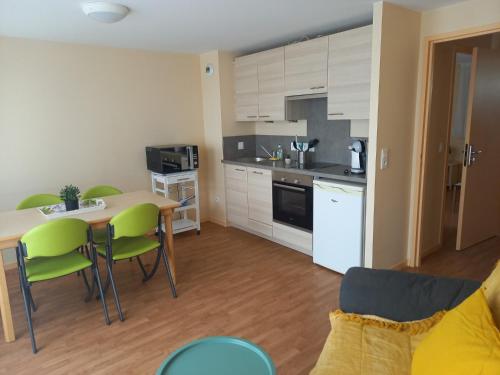 a kitchen and living room with a table and chairs at Centre Jean XXIII in Annecy