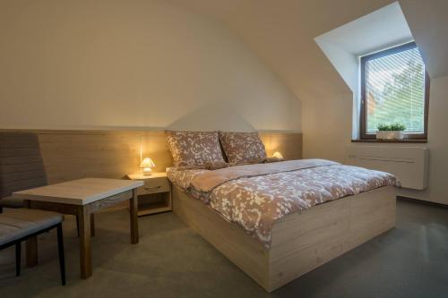 een slaapkamer met een bed, een tafel en een raam bij Hotel U Nádraží in Tepla