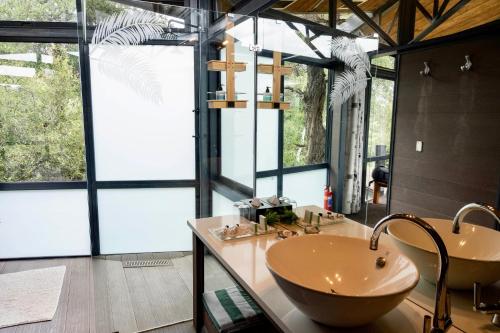 a bathroom with two sinks and a large window at Greenfire Game Lodge in Balule Game Reserve