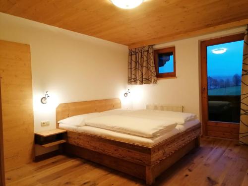 a bedroom with a bed and a large window at Landhaus Brixental in Westendorf