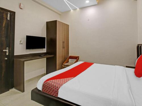 a hotel room with a bed and a tv at Hotel Four Petals in Bhopal