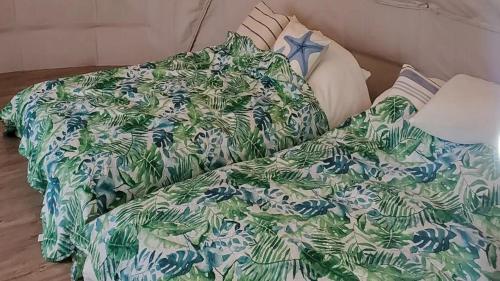 un letto con coperta e cuscini verdi e bianchi di Kakurega Shikinotsuki - Vacation STAY 13063v a Hokota