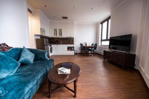 a living room with a blue couch and a table at MADELISE HOTEL&APARTMENT in Hai Phong