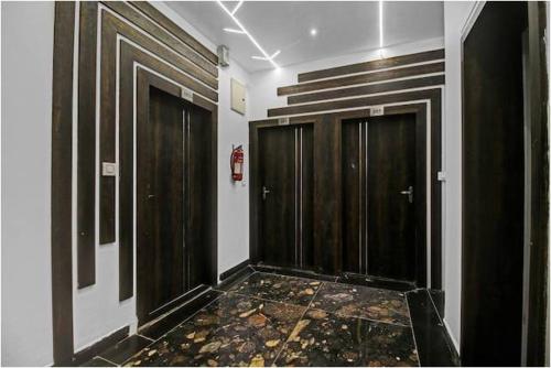 a hallway with two wooden doors in a room at Hotel Four Petals in Bhopal