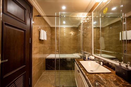 a bathroom with a sink and a glass shower at MADELISE HOTEL&APARTMENT in Hai Phong