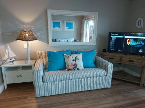 a living room with a couch and a tv at Belle View @ Knysna Quays in Knysna
