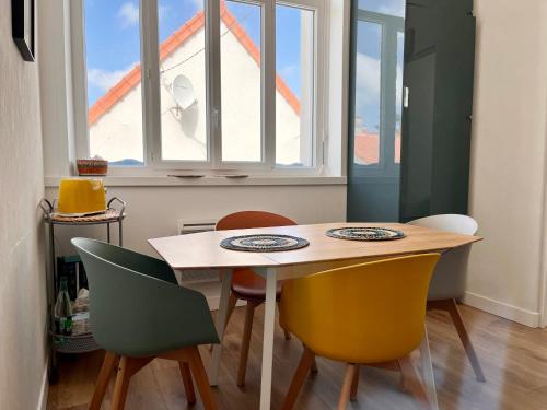 une table et des chaises dans une pièce avec une fenêtre dans l'établissement COC - Les Goélands, à Wissant