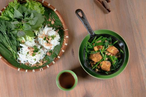 a table with a bowl of rice and a bowl of salad at ÊMM Hotel Saigon in Ho Chi Minh City