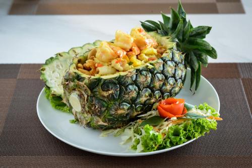 a plate of food with a pineapple on a table at Grand BS Airport Hotel Suvarnabhumi in Lat Krabang