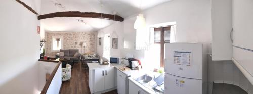 a kitchen with white cabinets and a white refrigerator at Casa del Maestro in Olmeda de las Fuentes