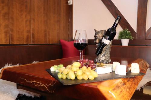 a table with a glass of wine and a plate of grapes at Hotel Weinhaus Wiedemann in Ginsheim-Gustavsburg