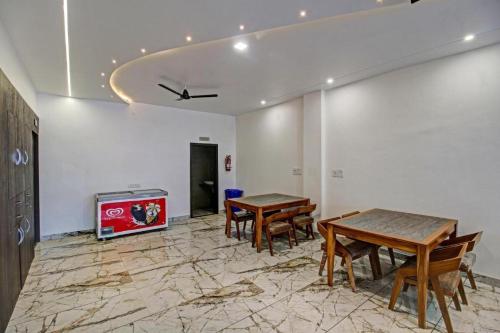 two tables and chairs in a room with a tv at Hotel Four Petals in Bhopal