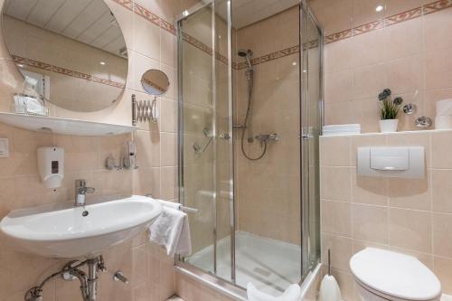 y baño con ducha, lavabo y aseo. en Hotel Weinhaus Wiedemann, en Ginsheim-Gustavsburg