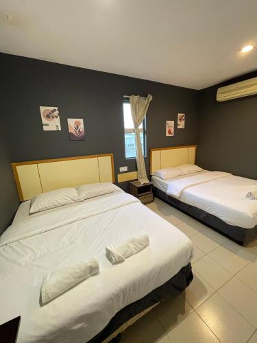 a bedroom with two beds and a window at Fresh Hotel Falim in Ipoh