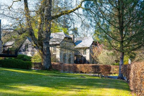 a large stone house with trees in the yard at Bovey Castle in Moretonhampstead
