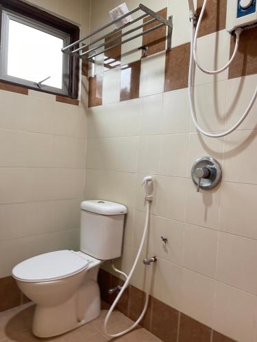 a bathroom with a toilet and a shower at Fresh Hotel Falim in Ipoh