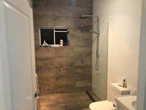 a bathroom with a shower and a toilet and a sink at Self Contained Apartment, Queen bed, Own deck & great views in Coolum Beach