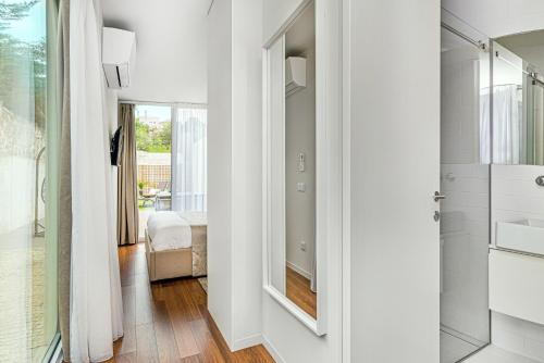uma casa de banho com um chuveiro, um lavatório e um espelho. em Luxury in the Art District by Innkeeper no Porto