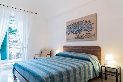 - une chambre blanche avec un lit et une fenêtre dans l'établissement Casa Nà Za Maria, à Modica