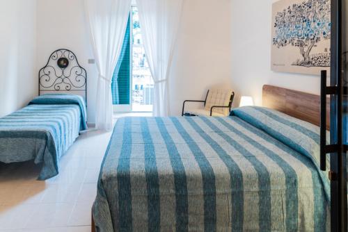 - une chambre avec 2 lits et une fenêtre dans l'établissement Casa Nà Za Maria, à Modica