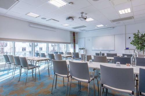 a conference room with tables and chairs and a whiteboard at Radisson Blu Hotel Uppsala in Uppsala