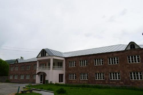 a large brick building with a metal roof at Aliq hotel in Tsaghkadzor