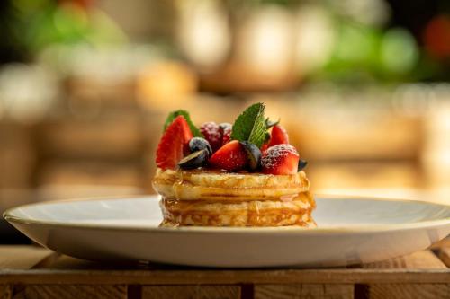 a stack of waffles with strawberries and mint on a plate at Radisson Blu Sobieski in Warsaw