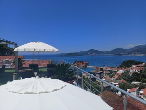 a balcony overlooking a beach with a view of the ocean at Guest house Villa Slavica in Sveti Stefan