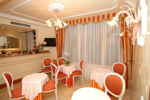 un comedor con mesas y sillas y una lámpara de araña en Hotel San Luca Venezia, en Venecia
