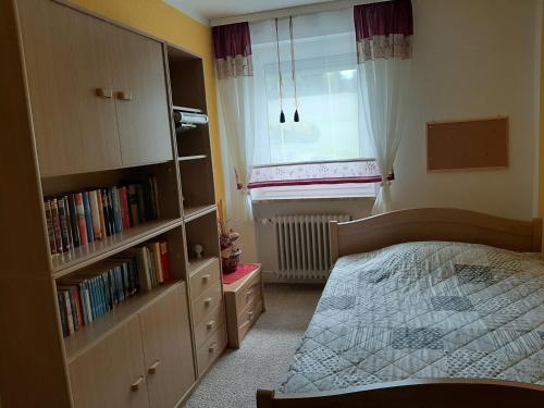 a bedroom with a bed and a book shelf at Ferienwohnung Schmidt in Naila