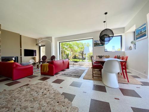 een woonkamer met een rode bank en een tafel bij Superbe villa vue sur mer, corniche de la plage in Bénodet