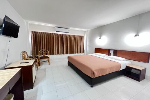 a hotel room with a bed and a television at Pure Phuket Residence in Phuket