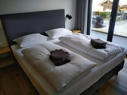 a bed with white blankets and pillows on it at Panorama Wohung in Hollersbach im Pinzgau