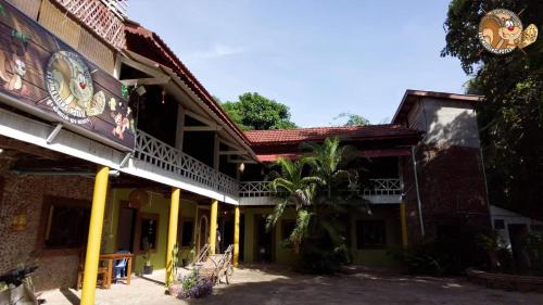 a building with yellow columns and a building with a tree at Kep Melting Potes in Kep