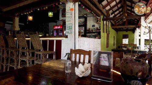 un restaurant avec une table et des chaises en bois ainsi qu'un bar dans l'établissement Kep Melting Potes, à Kep