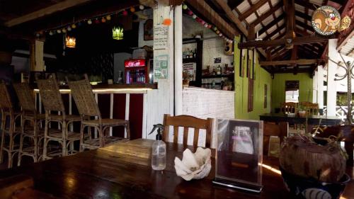 restauracja z drewnianym stołem i krzesłami oraz bar w obiekcie Kep Melting Potes w mieście Kep