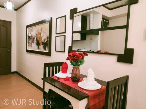 une table avec un tissu de table rouge et un vase de fleurs. dans l'établissement Centropolis Queen Bed Suite- Modern Posh Style, à Manille