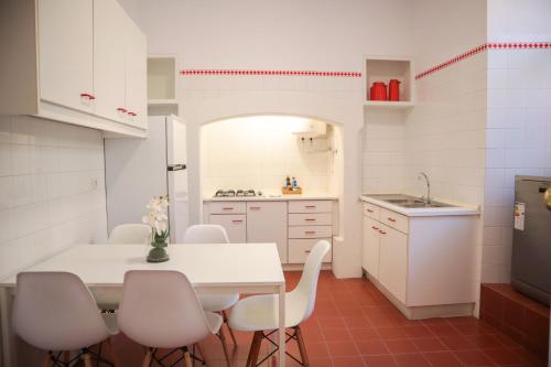 a kitchen with a white table and white chairs at The Residences at Bairro Alto in Lisbon