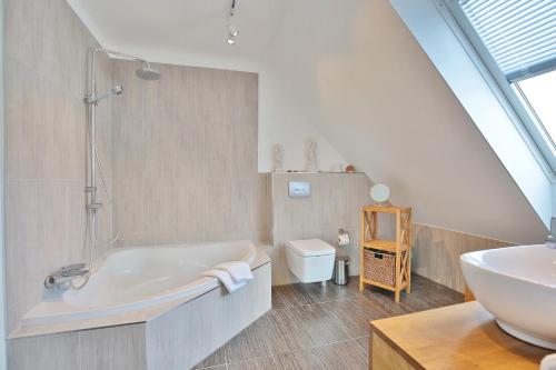 a bathroom with a white tub and a sink at Haus Meeresrauschen Haus Meeresrauschen Appartement 1 6 in Haffkrug