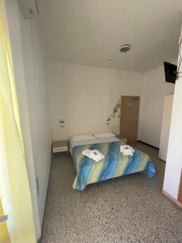 リミニにあるHotel moroniのベッド1台(タオル付)が備わる小さな客室です。