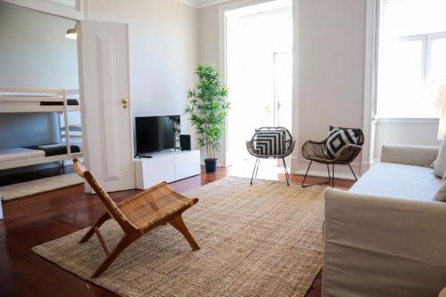 a living room with a chair and a couch at The Residences at Bairro Alto in Lisbon