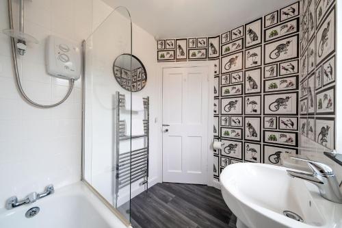 a bathroom with a white tub and a sink at The Palm at the Ferry in Broughty Ferry