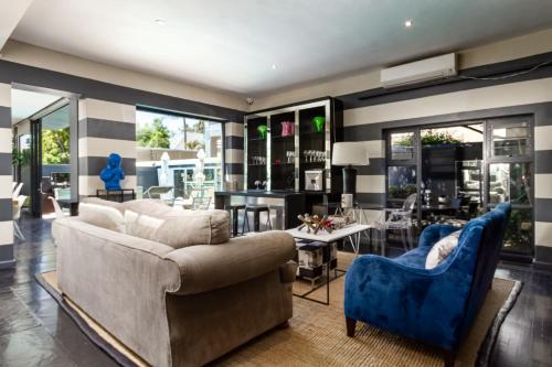 a living room with a couch and blue chairs at Life & Leisure Boutique Guesthouse in Stellenbosch