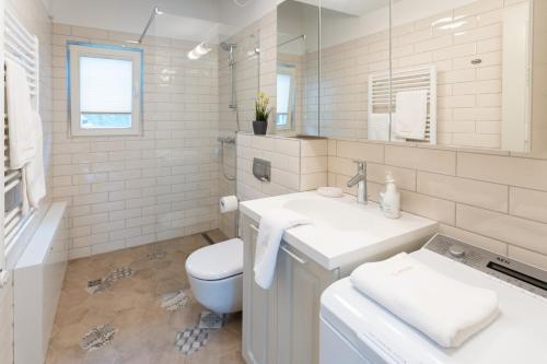Un baño blanco con lavabo e inodoro. en Preilos Perliukas, en Preila