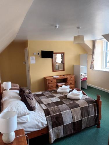 a bedroom with a bed and a dresser and a mirror at Inn at Ardgour in Onich