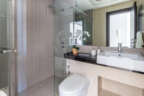 a bathroom with a toilet and a sink and a mirror at Frank Porter - Silverene Tower in Dubai