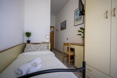 a small bedroom with two beds and a desk at Hotel Mamy in Rimini