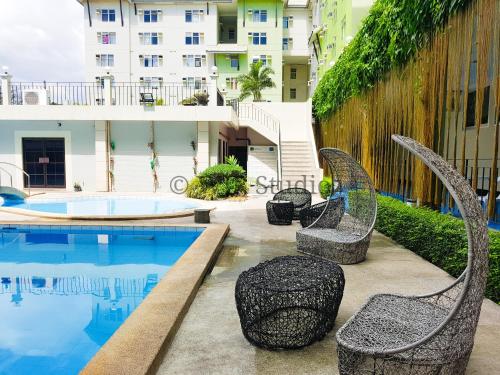 un patio avec des chaises à côté d'une piscine dans l'établissement Centropolis Queen Bed Suite- Modern Posh Style, à Manille