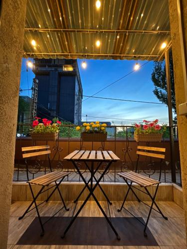 a patio with tables and flowers on a balcony at People Hostel in Bishkek